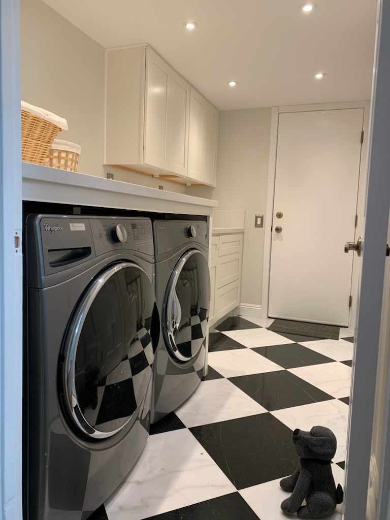 Custom laundry room with white shaker cabinetry and marble checkerboard tile floor