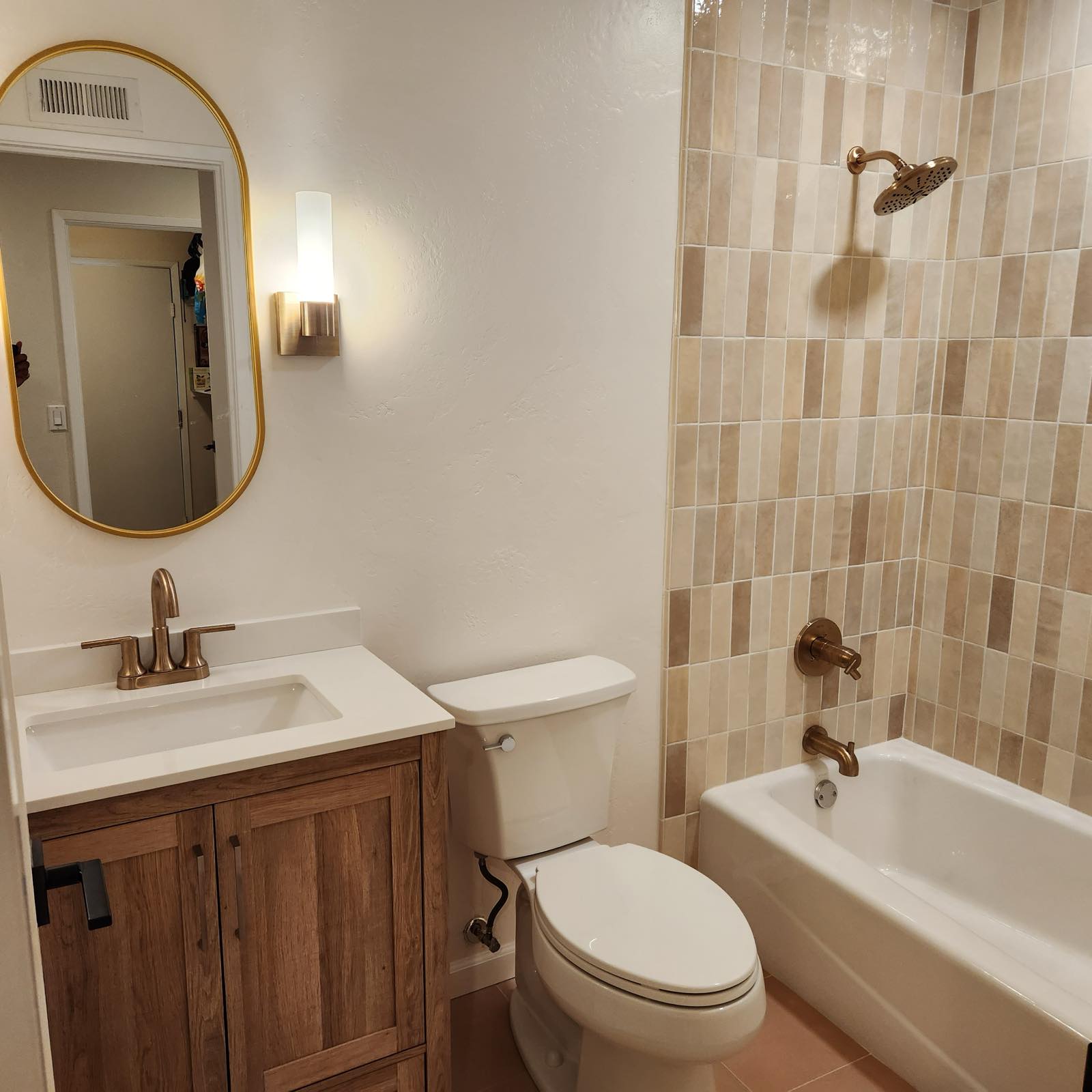 Full bathroom remodel with zellige tile tub surround, wood vanity, and brushed brass fixtures